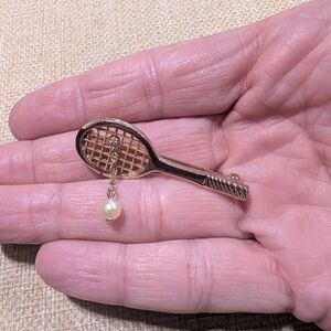vintage gold-tone Avon tennis racket brooch with an articulated faux pearl ball
